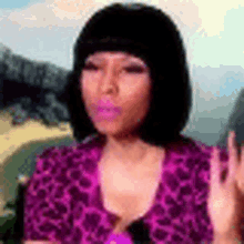 a woman wearing a purple shirt and a black wig is making a funny face .