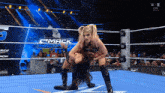 a woman in a wrestling ring with the word mack down on the wall behind her