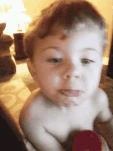 a baby without a shirt is looking at something
