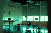 a man sits on a chair in a large room with a speaker on the floor