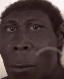 a close up of a man 's face with a hand on his chin