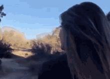 a woman looking out a window with a blue sky