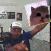 a man is holding up a picture of a cat in his hands