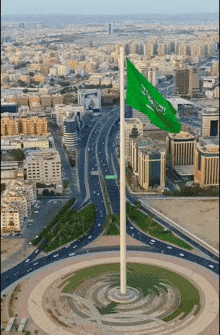 an aerial view of a city with a green flag flying