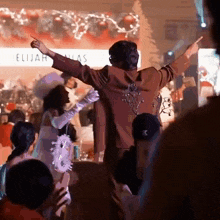 a man and a woman are dancing in front of a crowd .