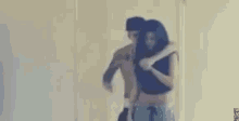 a man and a woman are hugging each other in front of a mirror in a room .