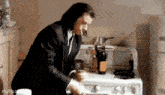 a man in a suit is cooking on a stove .