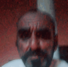 a close up of a man with a beard and mustache making a funny face .