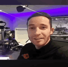 a man wearing a headset is sitting in front of a microphone in a studio .