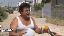 a man in a white tank top is being interviewed by someone holding a microphone that says big city news