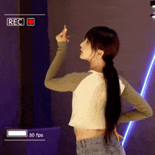 a woman is dancing in front of a screen that says rec 30 fps