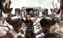a woman in a costume is standing in front of a large robot .