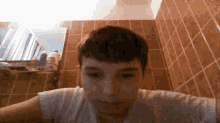 a young boy in a white shirt is looking at the camera