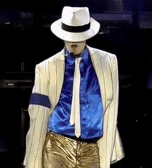 a man in a white hat and blue shirt is dancing