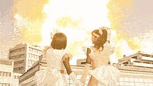 a couple of girls standing in front of a fireball