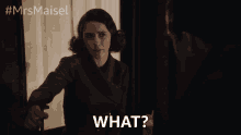 a woman in a red coat says " what " in front of a man