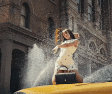 a woman in a white dress is kneeling on the back of a taxi