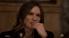 a close up of a woman 's face with the nbc logo in the background