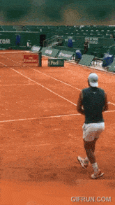 a tennis player on a court with a fedex sign