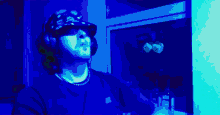 a man wearing a hat that says ' a ' on it is standing in front of a window