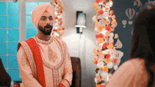 a man in a turban is standing next to a woman in a room
