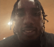 a close up of a man with braids on his head