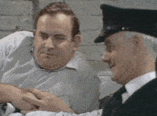 a man in a striped shirt is talking to a police officer