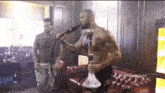 a shirtless man smoking a hookah in a room with the hashtag tafeupdatesx on the bottom