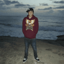 a man wearing a maroon hoodie that says strong on it
