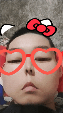 a person wearing red heart shaped glasses with a red bow