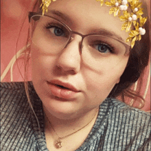 a girl wearing glasses and a necklace has a flower on her face