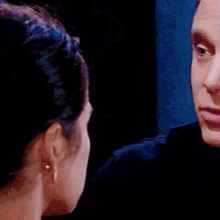 a man and a woman are touching each other 's faces in a dark room .