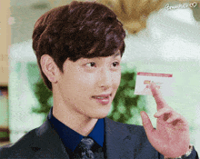 a man in a suit and tie holds up a card that says brow hair