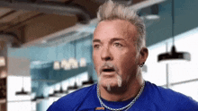a man with a beard wearing a blue shirt that says jojo