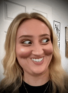 a woman is smiling and making a funny face with her eyes closed