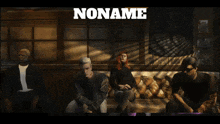 a group of people sitting on a couch with the word nomma in white
