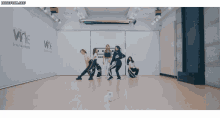 a group of girls are dancing in front of a wall that says wne entertainment