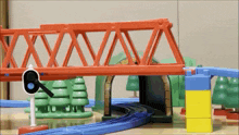 a toy train set with a red bridge and a sign that says 6 on it