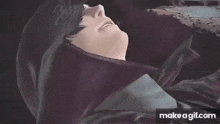 a person is laying down with their eyes closed and a purple cloth covering their head .