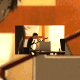 a man sits at a desk with a laptop and a guitar