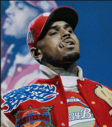 chris brown is wearing a red hat and a jacket that says chris brown