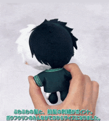 a person is holding a stuffed animal with chinese writing on the bottom