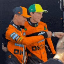 two men wearing orange shirts with the number 4 on them