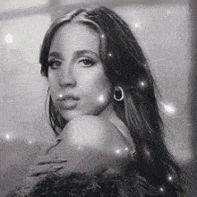 a black and white photo of a woman with long hair and hoop earrings