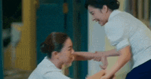 two women are playing with each other in a room and one of them is holding the other 's arm .