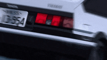 a white car with a license plate that says ' d954 ' on it