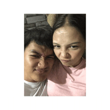 a man and a woman are posing for a picture and the woman is making a funny face