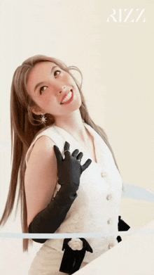 a woman wearing a white top and black gloves is smiling