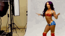 a woman in a wonder woman costume is dancing in a room .