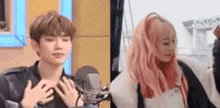 a man and a woman are standing next to each other in front of a microphone . the woman is wearing pink hair .
